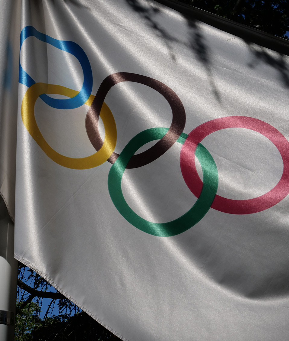 Bandera olímpica ondeada en los exteriores de la Facultad de Ciencias del Deporte. Se trata de una bandera blanca con los seis aros olímpicos y sus colores correspondientes
