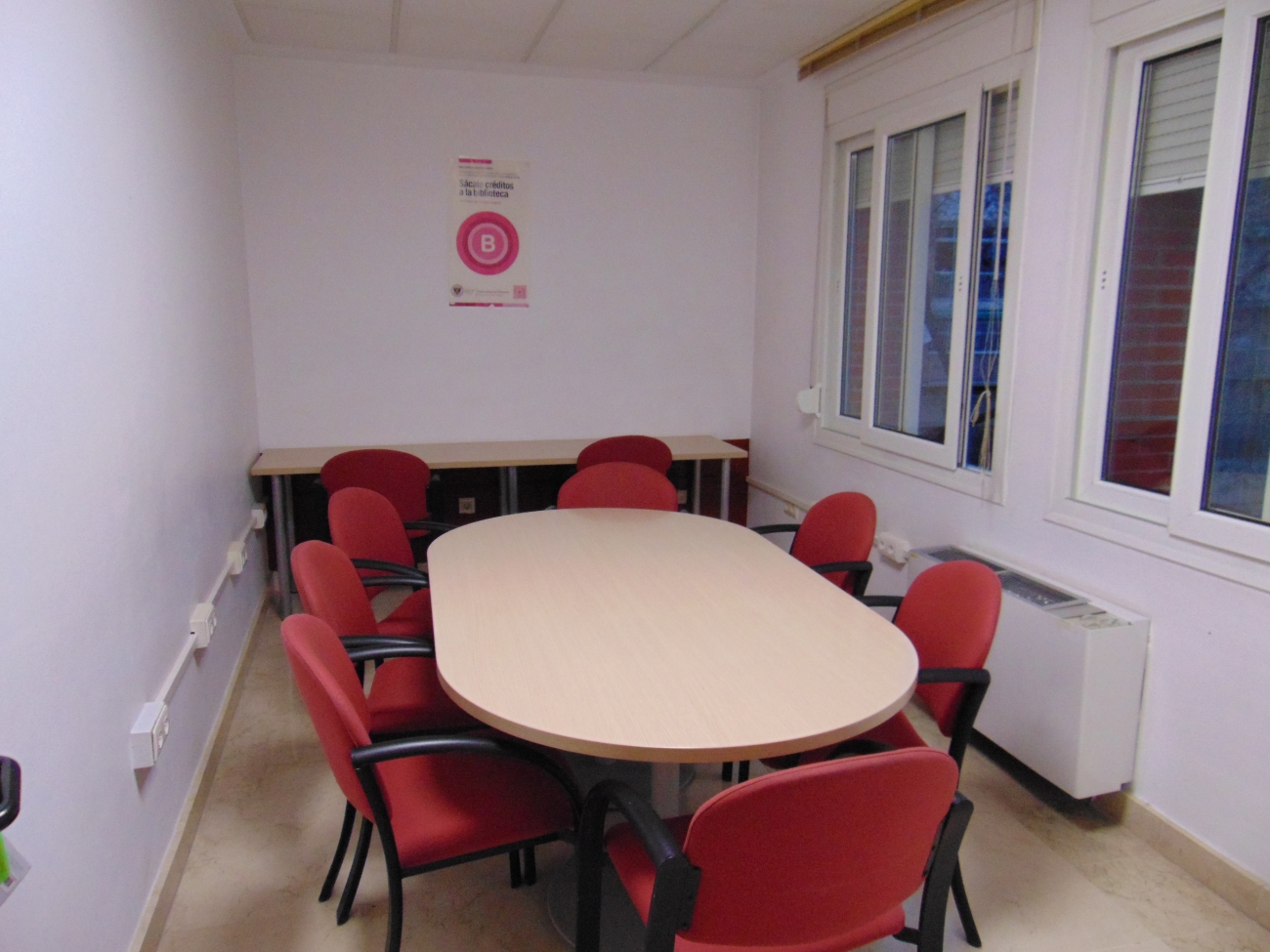 Foto con mesa y sillas de la sala para trabajo en grupo de la biblioteca