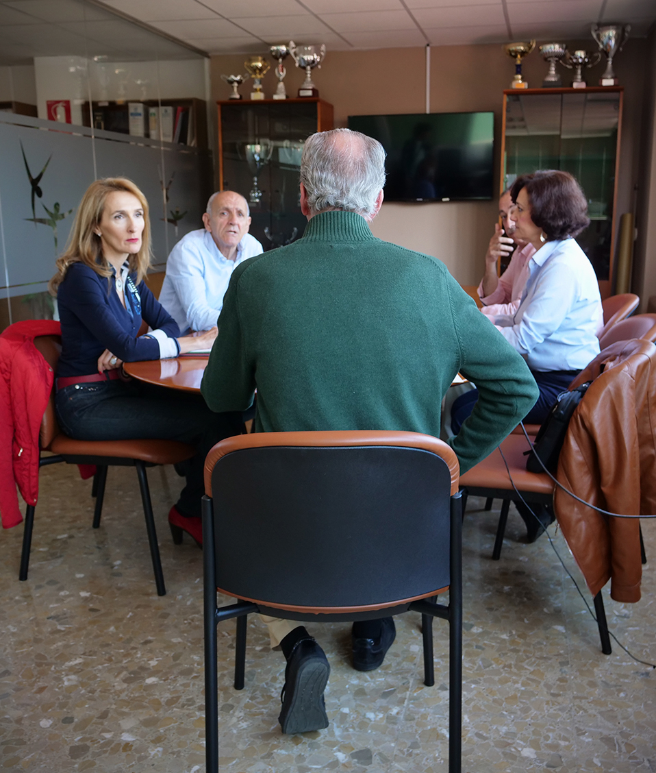 Cinco personas reunidas alrededor de la mesa de la sala de reuniones de la Facultad de Ciencias de Deportes